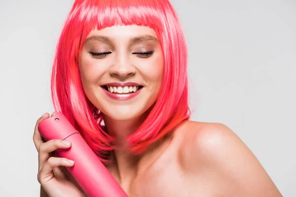 Happy naked girl in pink wig holding hair spray, isolated on grey — Stock Photo