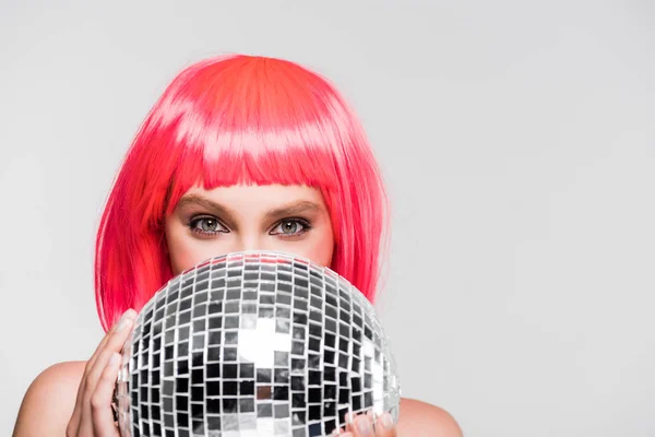 Bella ragazza in parrucca rosa con palla da discoteca, isolata su grigio — Foto stock
