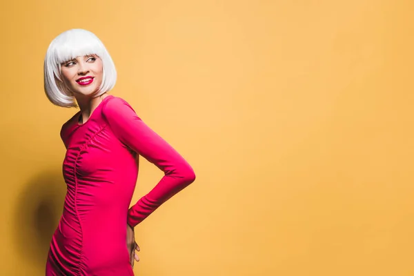 Bonita chica sonriente en peluca blanca aislada en amarillo - foto de stock