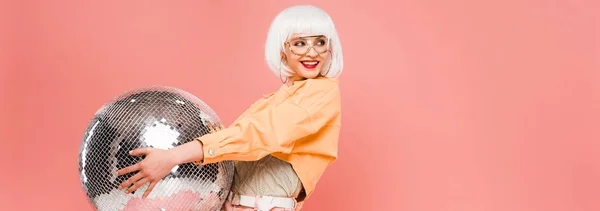 Menina da moda feliz em peruca branca posando com bola de discoteca, isolado em rosa — Fotografia de Stock
