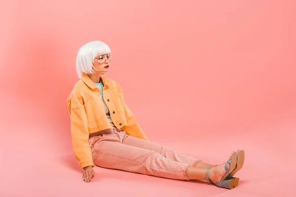 Beautiful girl in white wig posing like a doll on pink — Stock Photo