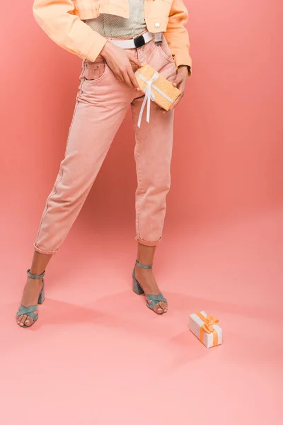Обрізаний вид стильної жінки з подарунками на рожевому — стокове фото