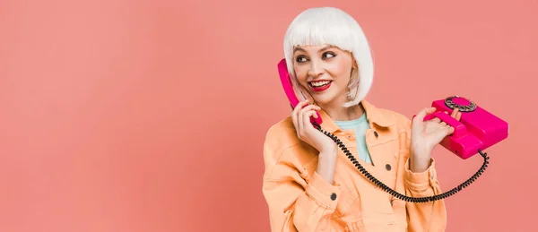 Belle femme élégante en perruque blanche parlant sur téléphone rétro, isolée sur rose — Photo de stock