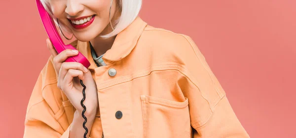 Recortado vista de la chica con estilo en peluca blanca hablando en el teléfono retro, aislado en rosa - foto de stock