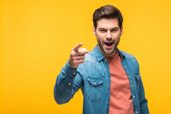 Excited handsome man pointing with finger isolated on yellow — Stock Photo