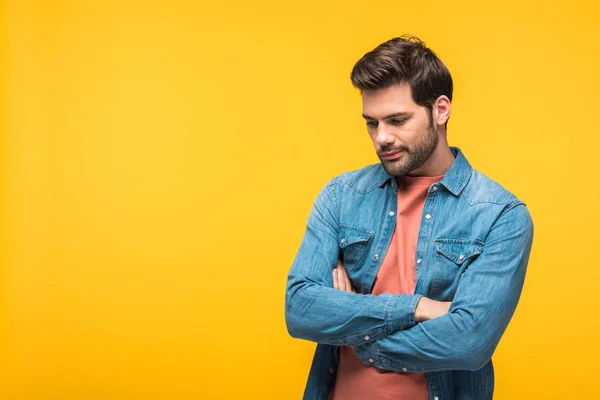 Bonito homem pensativo com cruzados braços isolado no amarelo — Fotografia de Stock