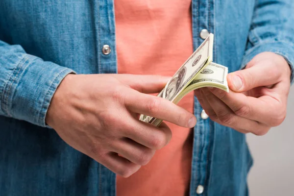 Ausgeschnittene Ansicht eines Mannes, der Geld auf Grau zählt — Stockfoto