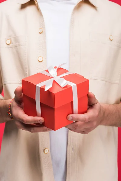 Partial view of man holding present with bow Isolated On pink — Stock Photo