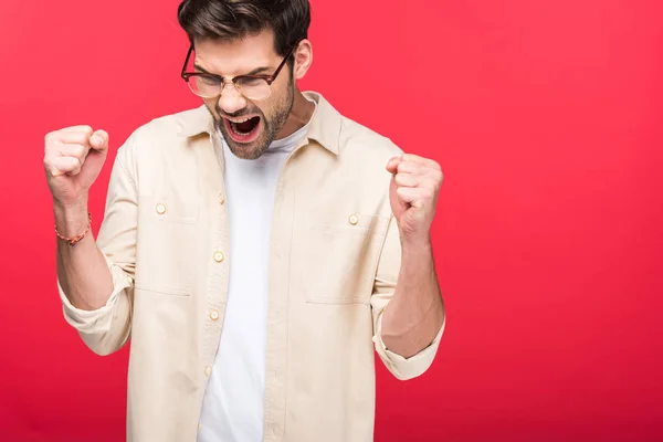 Excitado hombre guapo con los puños apretados aislado en rosa - foto de stock