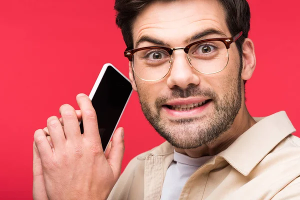 Homem confuso falando no smartphone e olhando para câmera Isolado em rosa — Fotografia de Stock