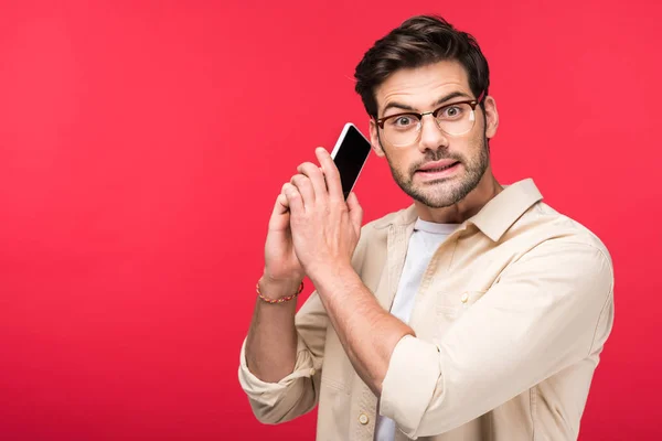 Homme confus parler sur smartphone et regarder la caméra isolé sur rose — Photo de stock