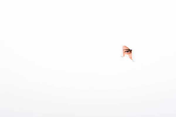 Mann schaut aus Loch in Papierwand auf weiß mit Kopierraum — Stockfoto
