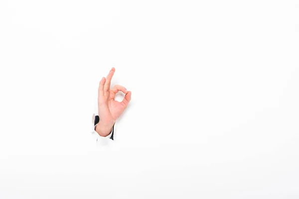 Man showing ok sign from hole in paper wall on white with copy space — Stock Photo