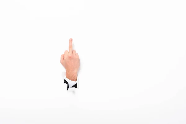 Man showing middle finger from hole in paper wall on white with copy space — Stock Photo