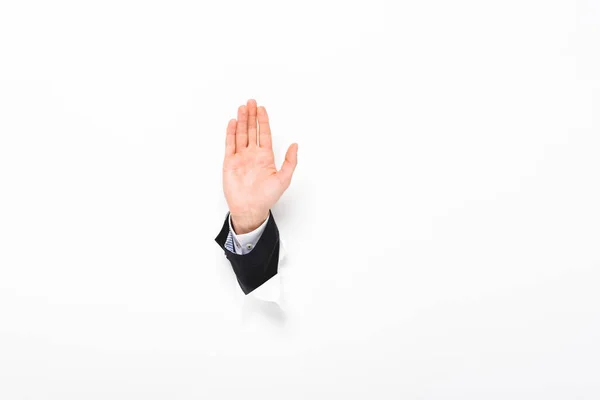 Cropped view of man showing stop sign from hole in wall on white with copy space — Stock Photo