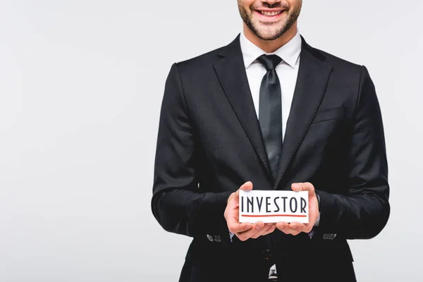 Cropped view of businessman in suit hodding card with investor word isolated on grey — Stock Photo