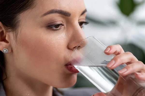 Porträt der schönen Geschäftsfrau mit verschwitztem Gesicht, die Wasser aus Glas trinkt, während sie unter Hitze leidet — Stockfoto