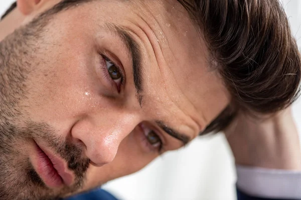 Retrato de hombre guapo agotado con la cara sudorosa que sufre de calor en blanco - foto de stock