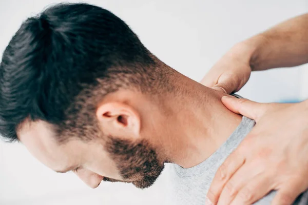 Ausgeschnittene Ansicht eines Arztes, der Patientin im Massageschrank der Klinik den Nacken massiert — Stockfoto