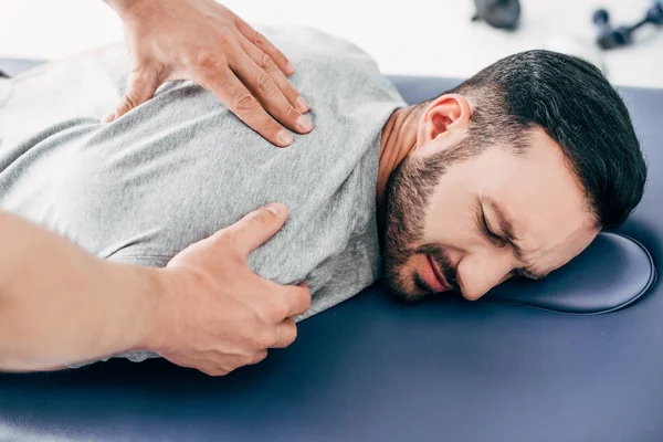 Quiropráctico masaje espalda de hombre en mesa de masaje en el hospital - foto de stock