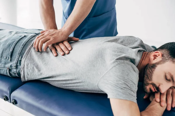 Chiropractor massaging back of man on Massage Table in hospital — Stock Photo