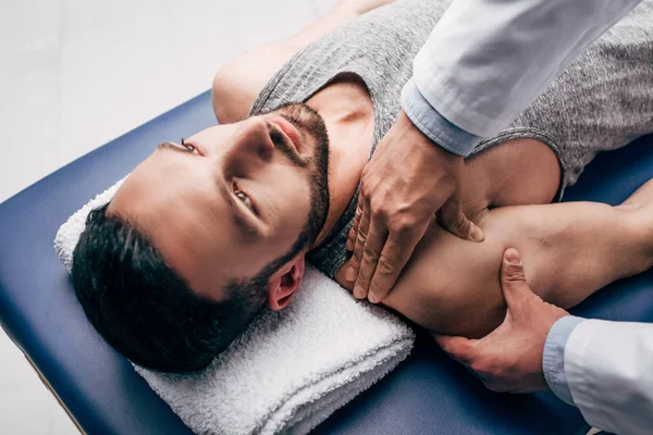 Quiroprático massagear ombro do homem na mesa de massagem no hospital — Fotografia de Stock