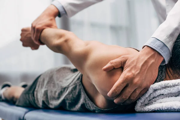 Enfoque selectivo del brazo de estiramiento quiropráctico del paciente en el hospital - foto de stock