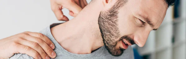 Plano panorámico de quiropráctico masajeando cuello de hombre - foto de stock