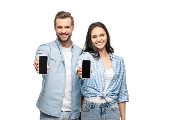Glücklicher Mann und junge Frau präsentieren Smartphones mit leerem Bildschirm isoliert auf weiß — Stockfoto