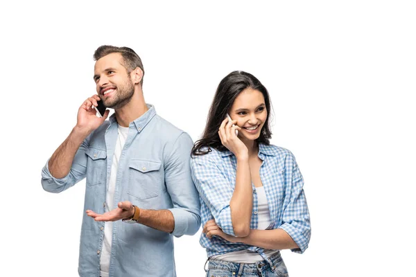 Hombre feliz y mujer joven hablando en teléfonos inteligentes aislados en blanco - foto de stock