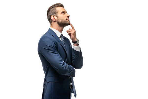 Bonito pensativo empresário no terno tocando queixo isolado no branco — Fotografia de Stock