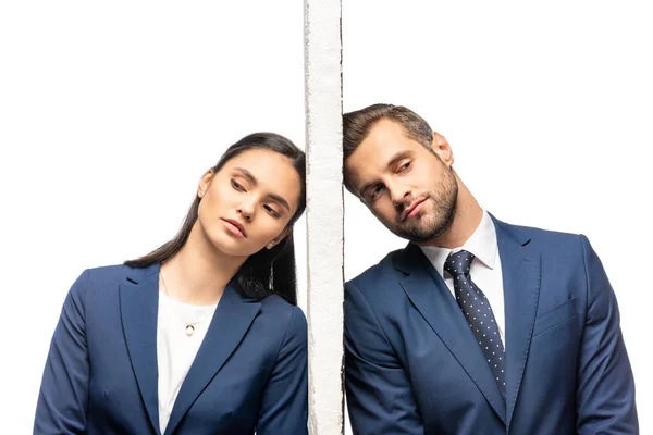 Molesto hombre de negocios y mujer de negocios separados por la pared aislada en blanco - foto de stock