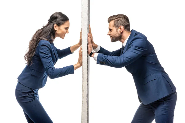 Angry businessman and businesswoman pushing wall isolated on white — Stock Photo