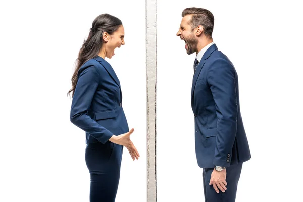 Angry businessman and businesswoman separated by wall yelling isolated on white — Stock Photo