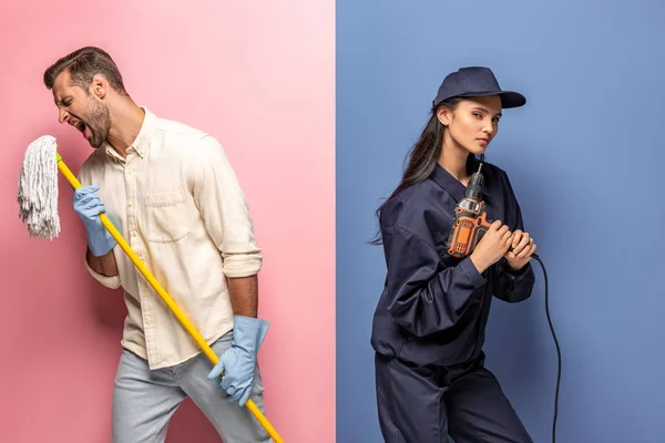 Homem em luvas de borracha cantando com esfregona e mulher em uniforme trabalhador de construção com broca em azul e rosa — Fotografia de Stock