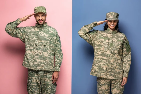 Mann und Frau in Militäruniform salutieren auf blau und rosa — Stockfoto