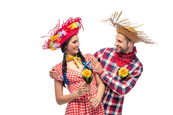 Hombre sonriente y mujer joven en ropa festiva con girasoles aislados en blanco - foto de stock