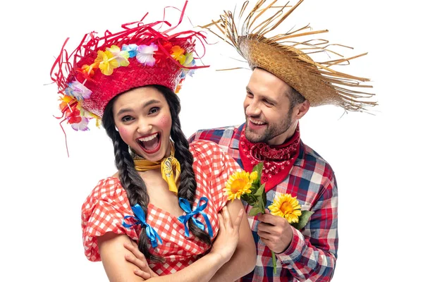 Hombre y mujer joven emocionada en ropa festiva con girasoles aislados en blanco - foto de stock