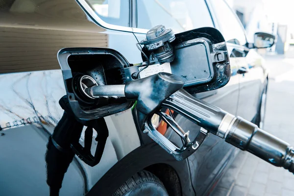 Selective focus of black modern automobile refueling with benzine on gas station — Stock Photo