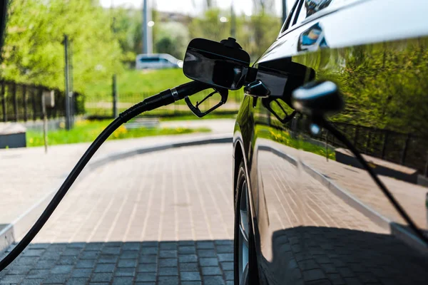 Selective focus of black automobile refueling with benzine on gas station — Stock Photo