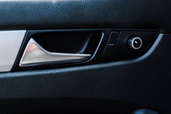 Metallic automobile door handle near buttons in modern car — Stock Photo