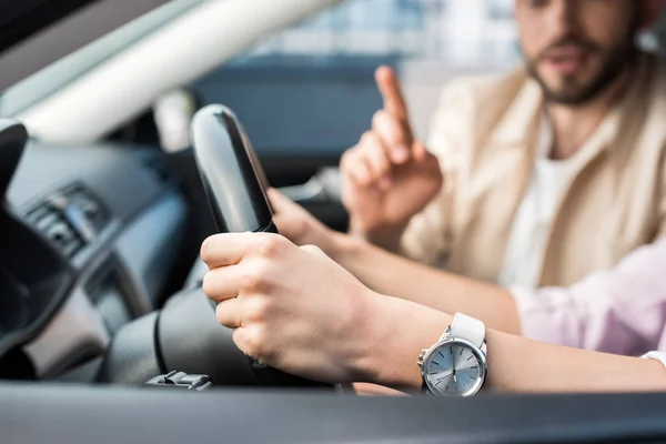 Cropped view of woman driving car near man pointing with finger — Stock Photo