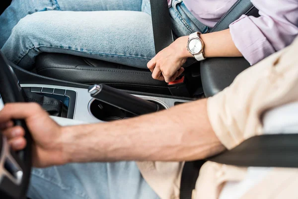 Vue aérienne de la femme attachant la ceinture de sécurité près de l'homme dans la voiture — Photo de stock