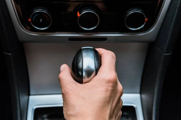 Cropped view of man holding handle of gear shift in car — Stock Photo
