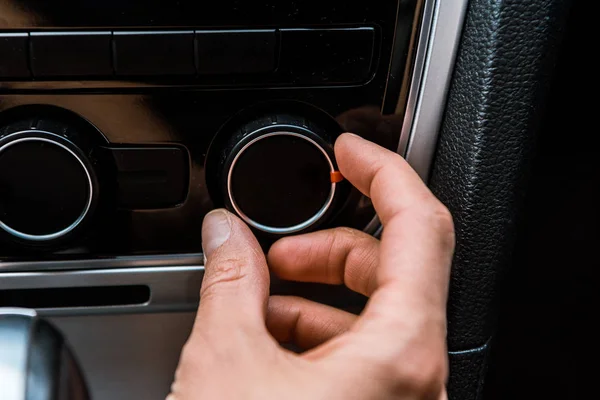 Обрізаний вид людини, яка торкається кнопки гучності в машині — стокове фото