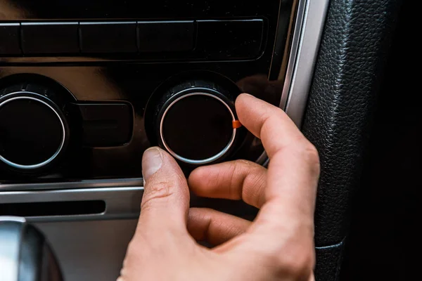 Vue recadrée de l'homme touchant bouton de volume dans la voiture — Photo de stock