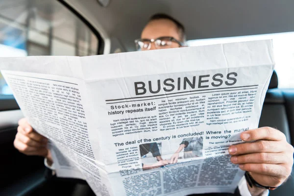 Selective focus of man reading business newspaper in car — Stock Photo