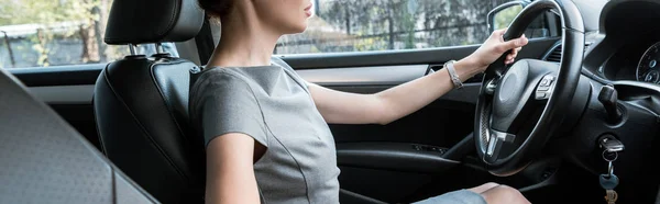 Tiro panorámico de la mujer sosteniendo el volante mientras conduce el coche - foto de stock