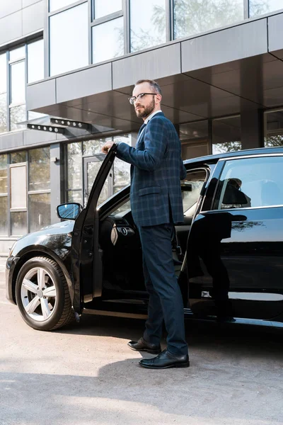 Tiefansicht eines Geschäftsmannes im Anzug, der in der Nähe eines schwarzen Autos steht — Stockfoto