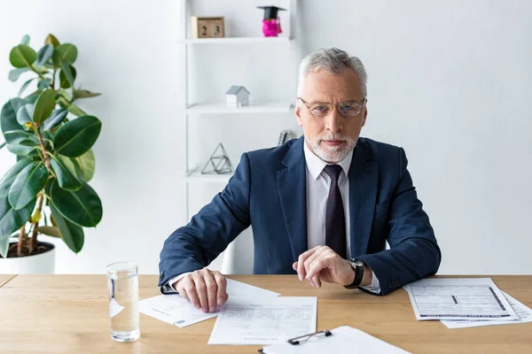 Schöner bärtiger Mann in formeller Kleidung, der im Büro in die Kamera schaut — Stockfoto